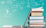 Stack of books with laptop on table